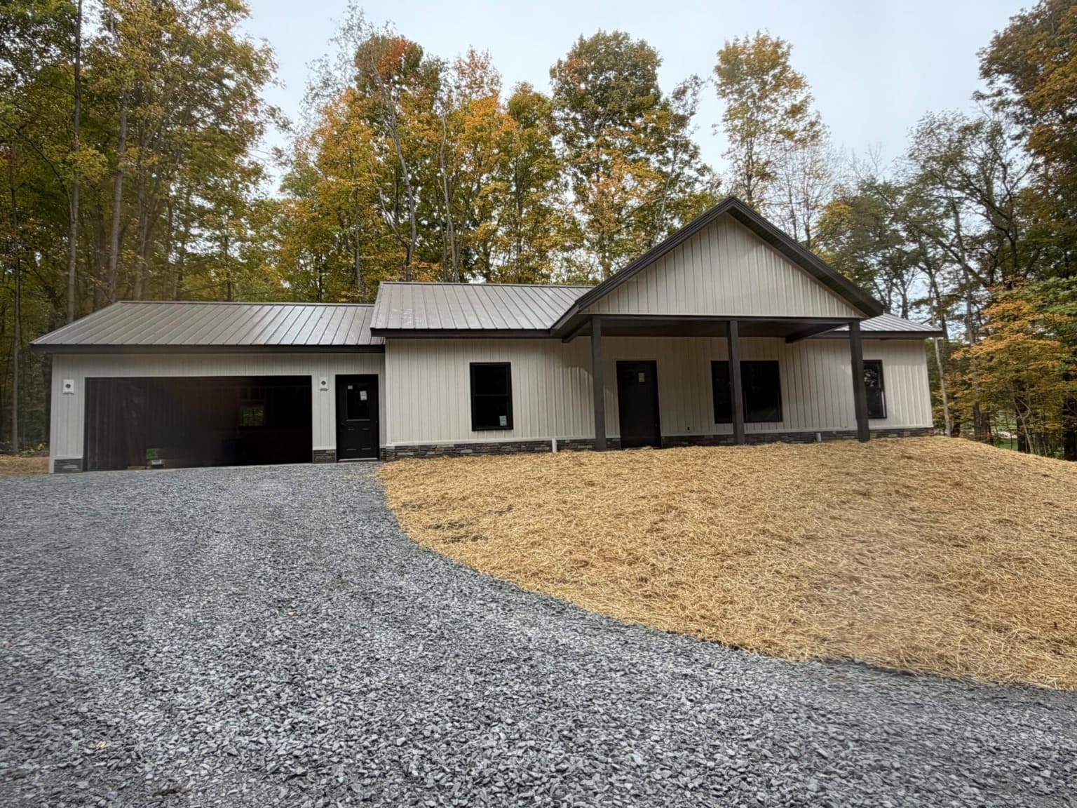 Ranch home with white board and batten siding, metal roof and attached garage