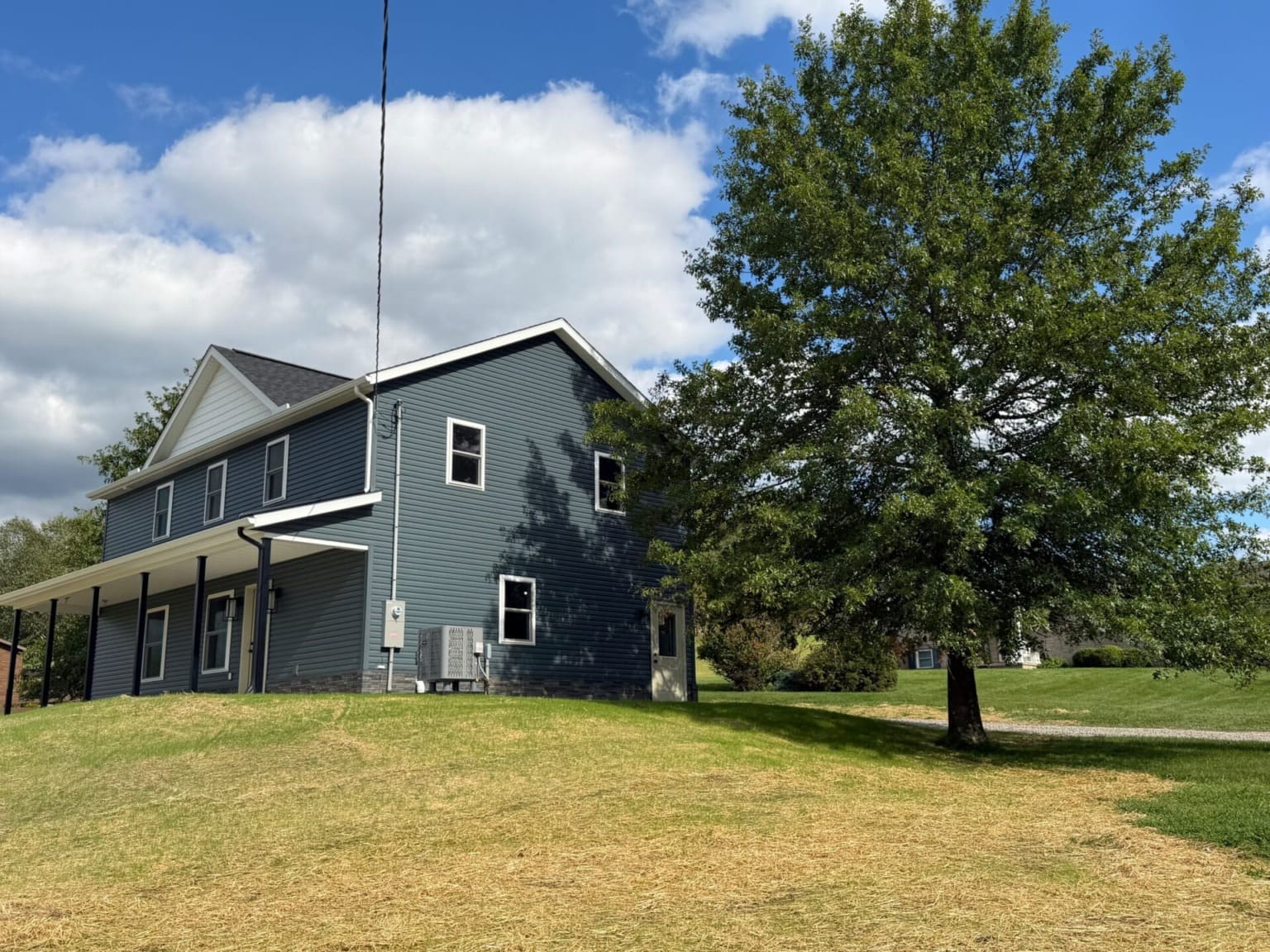 Two-story home with covered front porch and blue siding
